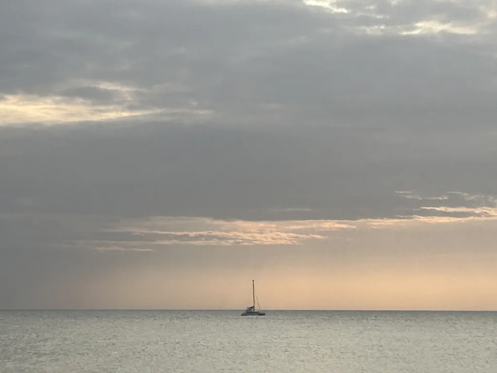 A lone sailboat at dusk.